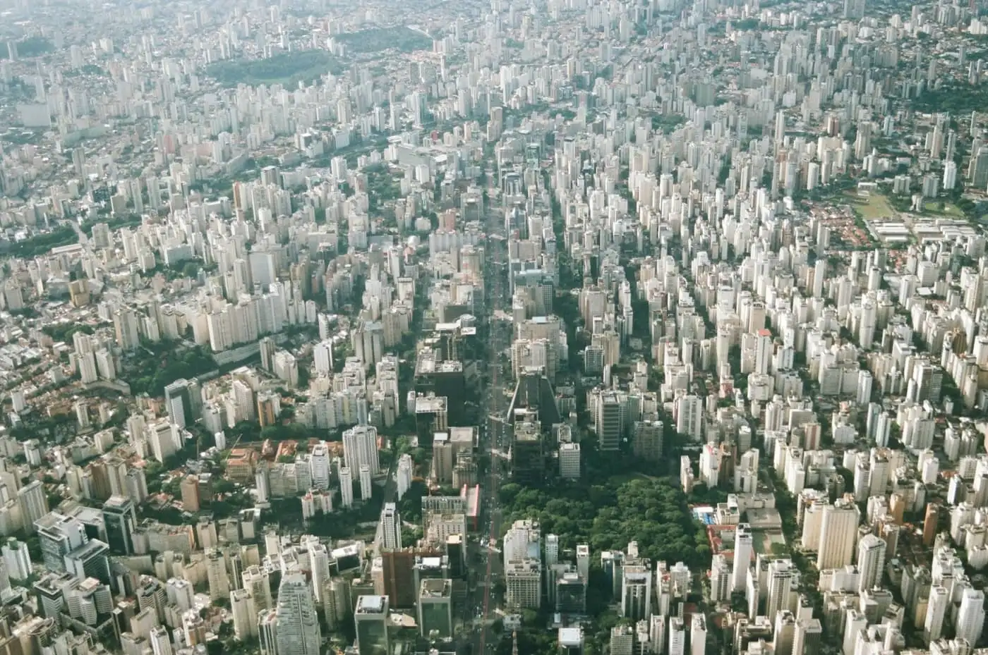 Vista aérea de São Paulo mostrando malha urbana densa de edifícios residenciais cortada por avenidas